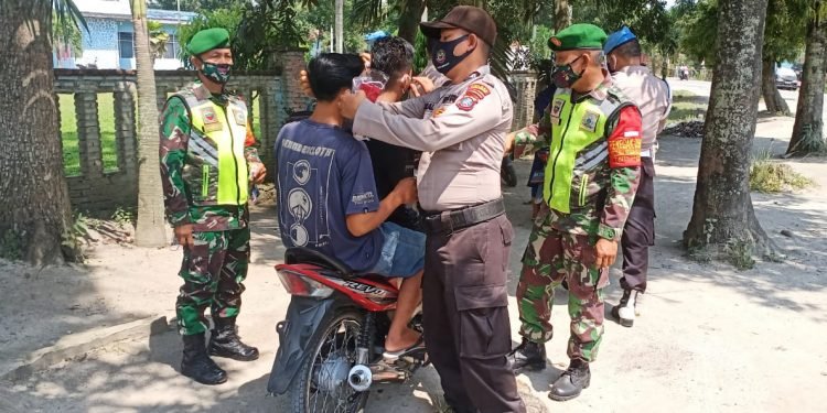 Terapkan pendisiplinan penggunaan masker Kapolsek Perdagangan bersama Forkopimca kecamatan Bandar bagikan masker