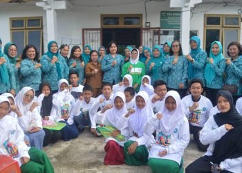 dr Susanti menyerahkan bantuan berupa kebutuhan sekolah kepada para pelajar dan bantuan kepada kader TP PKK Kelurahan Setia Negara