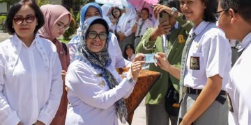 dr Susanti Dewayani SpA menyerahkan secara simbolis KTP Elektronik kepada siswa-siswi usia pemula di SMA Negeri 4 Pematangsiantar